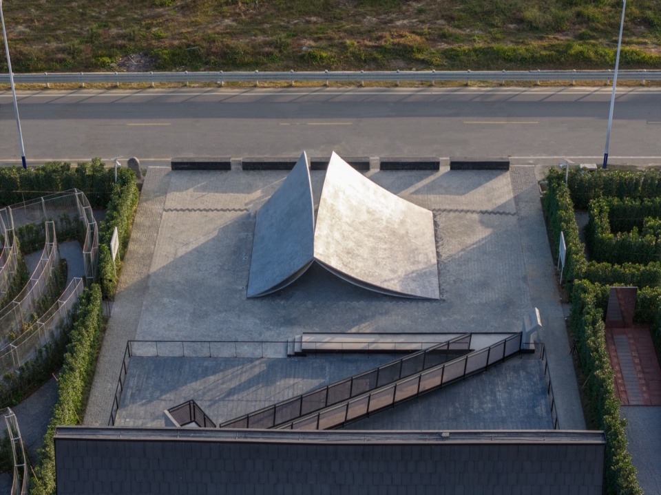 Aerial view of two folded plate forms like open book pages on a paved square, Pages Afloat by f-a-n in Huizhou