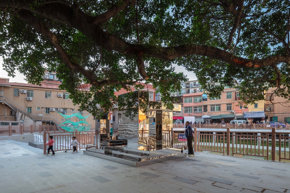 Mirror stainless steel Sea Reef art installation under a banyan tree in a Xiamen village square