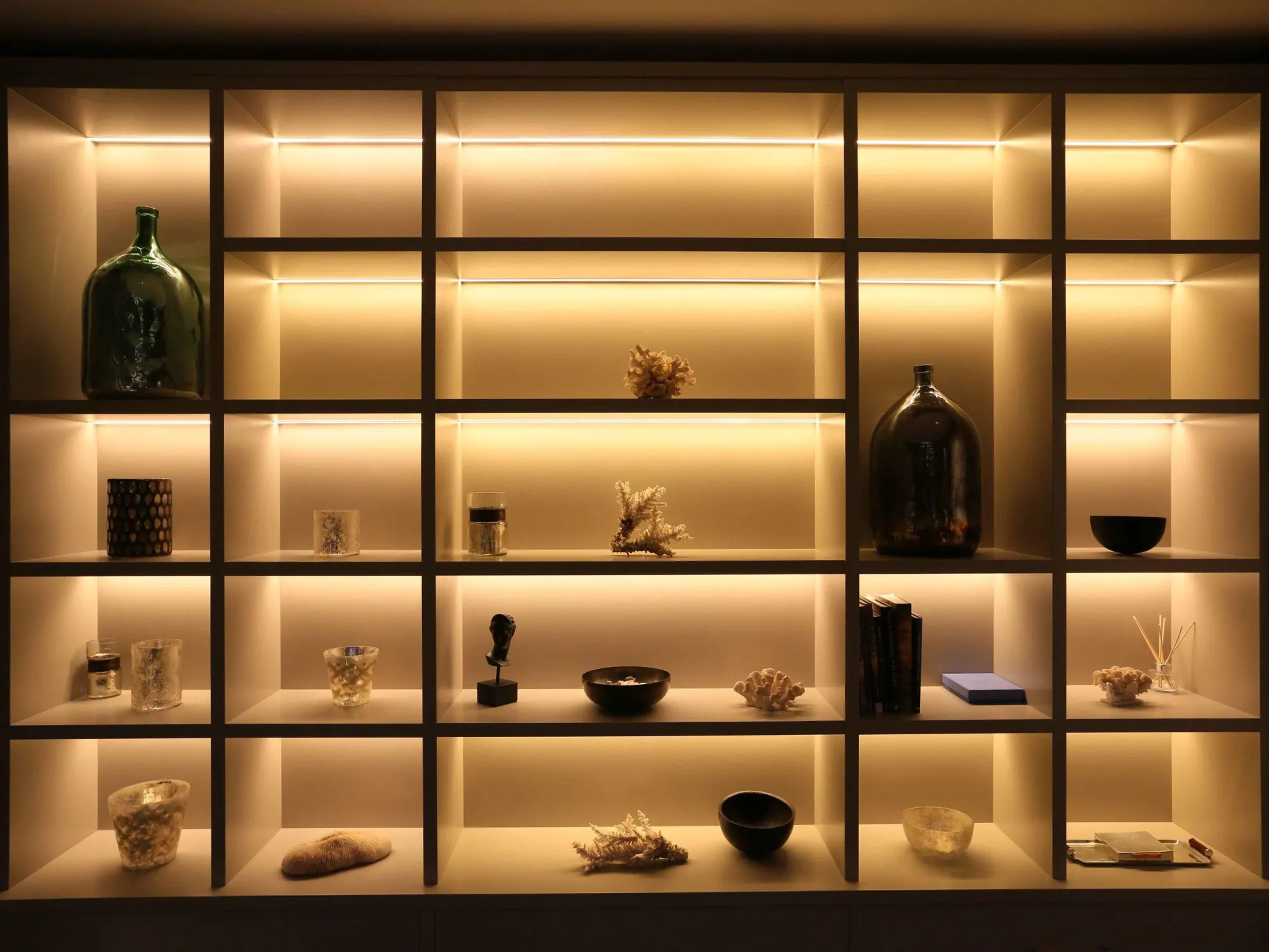 Custom LED display cabinet wall with warm shelf lighting by Elite Fixtures